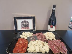 Plateau de charcuterie et fromage avec une bouteille de vin rouge